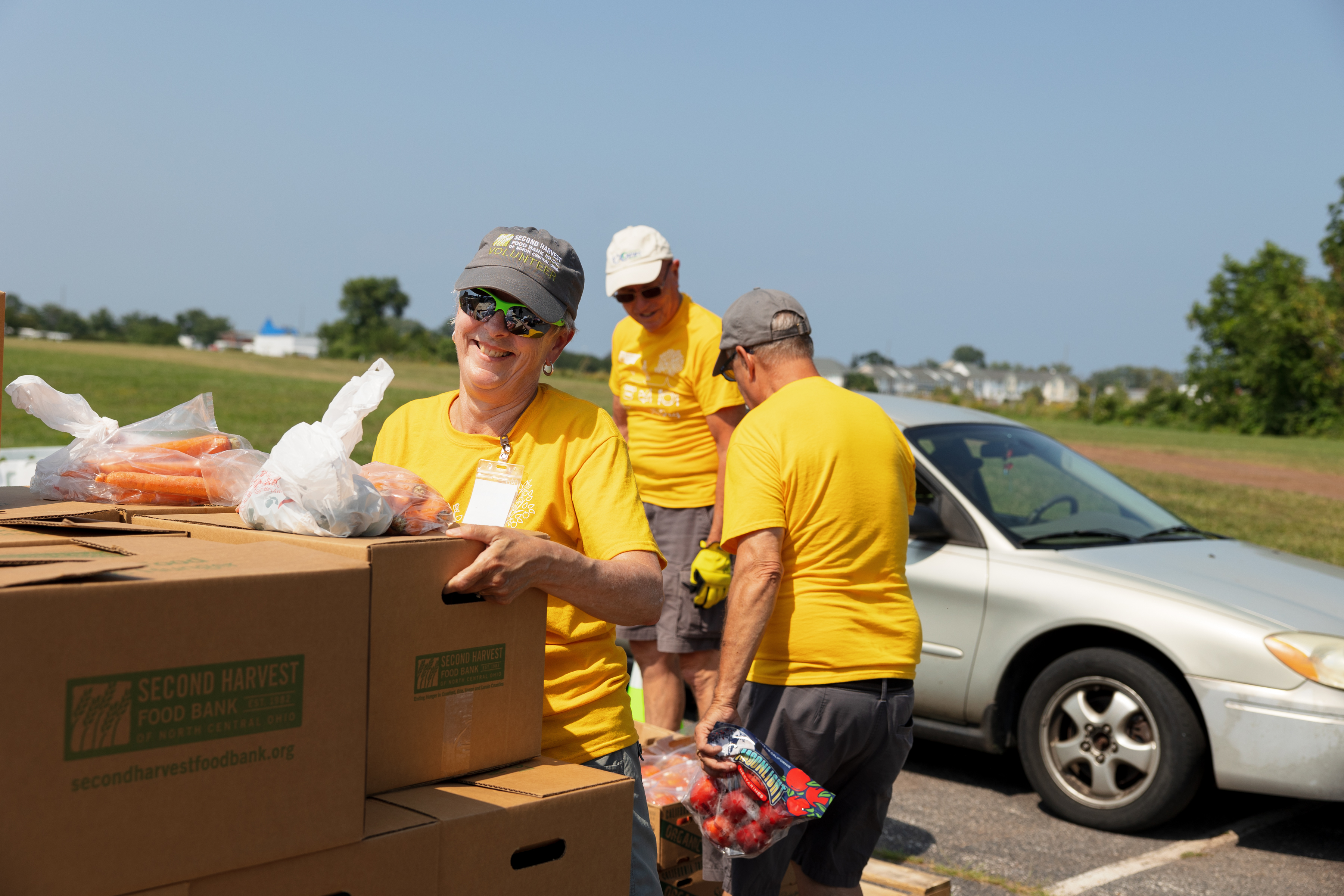 Volunteer picking up a box at a Drive-Thru Mobile Pantry.